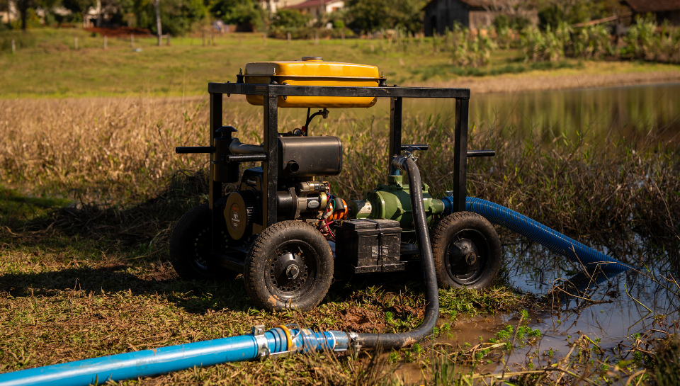 Motobomba elétrica nas margens do açude para iniciar irrigação com carretel