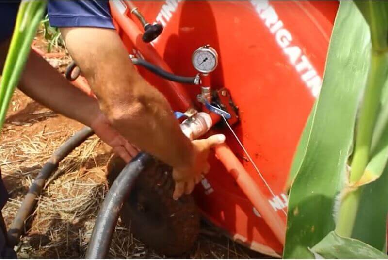 Profissional instalando mangueira no carretel de irrigação.